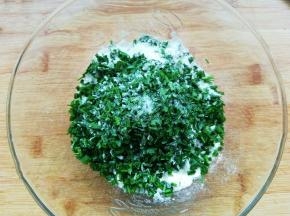 把韭菜叶放入碗中，加入适量盐（大约2g）搅拌均匀，腌制10分钟。