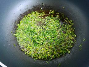 这个空档我们来处理韭菜根。起锅热油，油热下入韭菜根翻炒，适量盐调味，炒香后关火盛出。