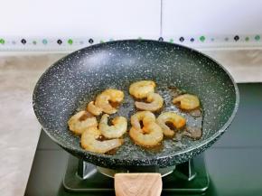 起油锅，倒入腌制好的虾仁煸炒至变色，盛出备用。