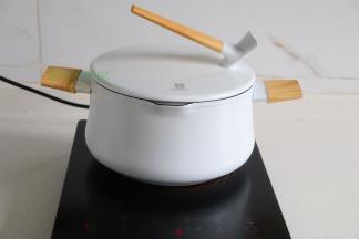 汤锅倒入适量的水，盖上盖子煮沸之后。盖子容易煮熟，可以节省时间、节约能源。