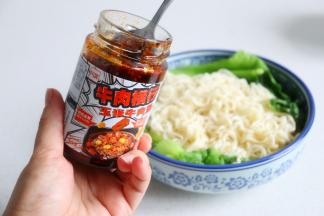 生菜、面条、牛肉酱、香葱，放入一个面团碗里，接着倒入热油，用筷子搅拌均匀。热乎乎的面条劲道滑爽，很好吃。