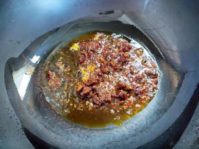 锅烧热，倒入比平常炒菜少一点油，大概三四十毫升吧，因为酱里面也是有油的。先下姜丝爆香，然后倒入牛肉酱，煸炒一分钟。