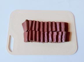 把鸭血放在案板上，横着切一下再切成小块。