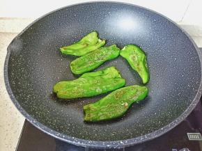 开小火将青椒两面煎成虎皮状。