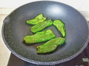 开小火将青椒两面煎成虎皮状。