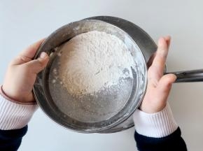 把低筋面粉、玉米淀粉和泡打粉混合，过筛到混合好的液体食材中。