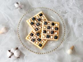 把奶油挤到华夫饼的格子里，表面筛上糖霜即可。