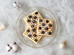 把奶油挤到华夫饼的格子里，表面筛上糖霜即可。