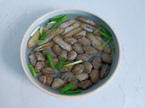 花蛤放入碗里，加入葱段。