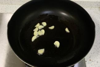 热锅倒入食用油，加入蒜片爆香。