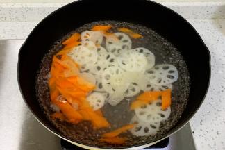 锅中水沸腾，加入藕片和胡萝卜焯水1分钟捞出。