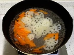 锅中水沸腾，加入藕片和胡萝卜焯水1分钟捞出。
