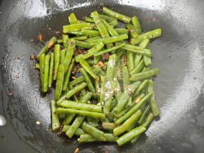 下入四季豆，翻炒均匀，加入盐，继续翻炒均匀