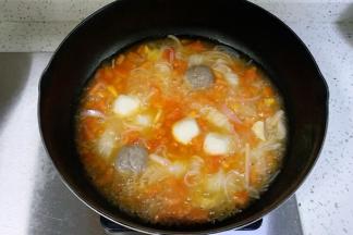 倒入适量的清水，放入蟹肉棒、鱼丸和牛肉丸，煮至浮起。