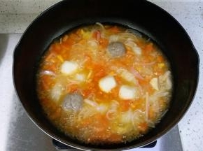 倒入适量的清水，放入蟹肉棒、鱼丸和牛肉丸，煮至浮起。