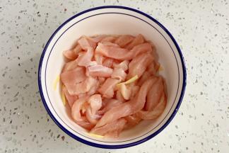 往鸡胸肉里加入料酒和姜丝，腌制15分钟。