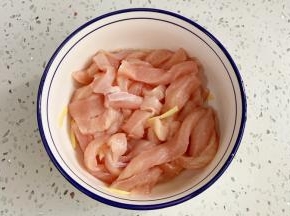 往鸡胸肉里加入料酒和姜丝，腌制15分钟。