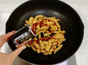 锅中倒入1勺食用油，放入炸好的鸡柳，倒入糖醋汁调味汁。