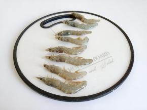 把对虾放案板上，刀顺着虾尾横着往虾头，把对虾切成对半。