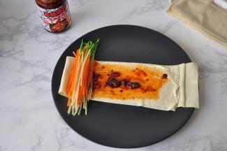 取一部分豌豆苗和一部分胡萝卜丝放在一端，注意，两头都要露出点菜来。