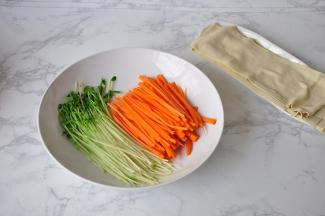 将焯过的豆皮略放凉后切成长条状，我一张豆皮切成了六份，然后其它配菜也备好。