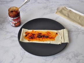 取一张豆皮平铺，然后涂上牛肉酱。