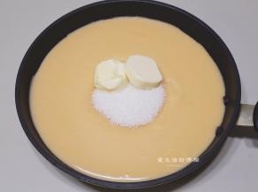打好的绿豆糊放入不粘锅里，把金沙馅的所有材料倒入锅里，小火慢熬，过程不断地用硅胶刀搅拌翻炒，水分会越来越少。