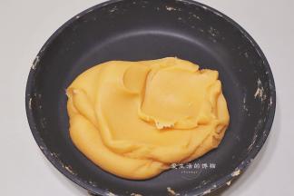 炒到绿豆糊变得细腻顺滑，并且不刮硅胶铲后就可以熄火了，如图中这种细腻柔滑的状态，太干或太湿都会容易让酥烤爆或变形，炒好的金沙馅盖住表面放凉即可使用。