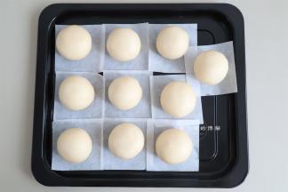 收口朝下放在油纸上，全部做好后，刷上一层蛋黄液，撒上白芝麻。