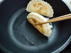 韭菜盒子两面都煎得金黄后，用筷子夹着，将边缘也煎一下，这样更好吃。