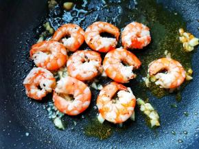 锅里爆香蒜末，加虾仁炒至变色，