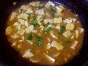 豆腐完全炖熟放入盐和味精调味最后撒上香菜提鲜即可出锅享用