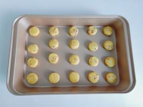 每个面团揉圆放在手心按一下，放在烤盘里面。