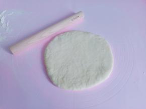 发酵好的面团分成两份，用擀面杖擀成圆形【喜欢饼底薄一点的也可以分成三份】