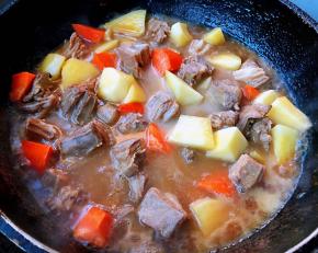 羊肉炖至六成熟时放入土豆和胡萝卜块改中火继续炖二十分钟