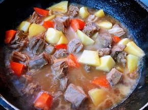 羊肉炖至六成熟时放入土豆和胡萝卜块改中火继续炖二十分钟