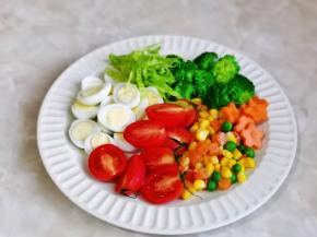 鹌鹑蛋与小番茄对半切开，生菜洗净切丝，还压了几片胡萝卜小花。