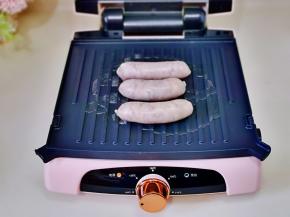 放上牛肉肠100度两面各煎2分钟，取出切花刀。