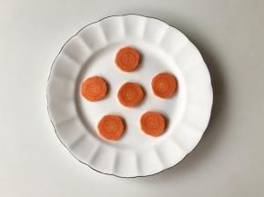 胡萝卜去皮，切成片，摆在盘子里，做丸子的底座。