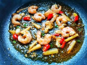 锅中热油爆香姜蒜小米椒，加入虾仁炒至变色，