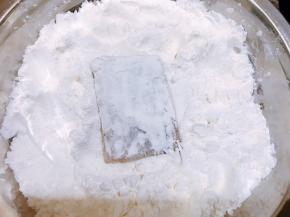 玉米淀粉和面粉混合均匀装在平盘里，把腌制好的带鱼段两面沾上干粉