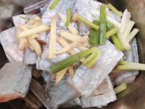 沥干水份后加入料酒，葱白段和姜丝