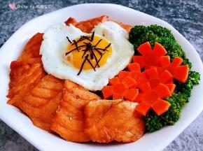 米饭上面摆上煎好的三文鱼、、西兰花、胡萝卜、爱心煎蛋撒上海苔碎就大功告成了