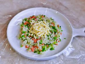用一块保鲜膜铺在餐盘上，放上饭，加入芝士包起来捏紧。