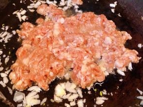 猪肉剁成馅用一品鲜酱油、蚝油、葱、姜煨制二十分钟入味，锅中倒入底油加热放入蒜粒爆香再放入猪肉馅