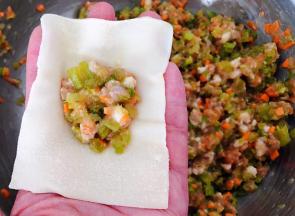 取一个馄饨皮将适量的馅料放入中间