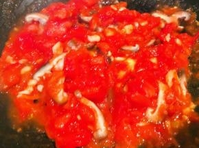 另起锅倒入少许底油加热放入蒜粒爆香再放入西红柿炒出汤汁再放入香菇炒匀