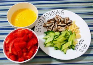 鸡蛋打散搅拌均匀西红柿洗净切成小块蒜切粒黄瓜和焯好水的香菇切成片备用