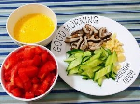 鸡蛋打散搅拌均匀西红柿洗净切成小块蒜切粒黄瓜和焯好水的香菇切成片备用