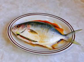 鲳鱼肚子里塞入姜丝与葱段，腌制20分钟。